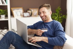 Smiling man during online shopping at home